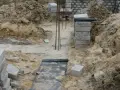 Wykonano wykopy pod fundamenty. Widać zbrojenie, betonowe bloczki i ziemię.