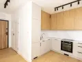 Nowoczesna kuchnia i przedpokój. Zastanawiasz się, ile kosztuje remont mieszkania? Ten projekt to inspiracja.