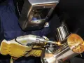 Operator w masce spawalniczej wykonuje napawanie laserowe metalowych elementów, tworząc iskrzące spoiny.