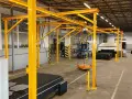 W hali przemysłowej montowane są różne rodzaje suwnic. Żółta konstrukcja wspiera system podnoszenia.