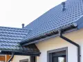 Szary dach z dachówki ceramicznej, system rynnowy. Sprawdź aktualną dachówka ceramiczna cena za m2.