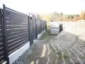 Solidny fundament pod bramę przesuwną, gotowy na montaż nowoczesnego ogrodzenia. Obok materiały budowlane.
