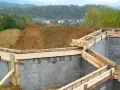 Fundamenty domu w budowie, zbrojenie i szalunki czekają na beton. Widać, ile jest ważne pozwolenie na budowę, by móc rozpocząć taką inwestycję.