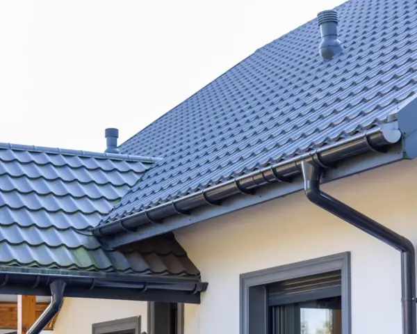 Szary dach z dachówki ceramicznej, system rynnowy. Sprawdź aktualną dachówka ceramiczna cena za m2.